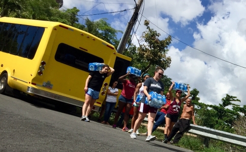 students carrying supplies from a bus